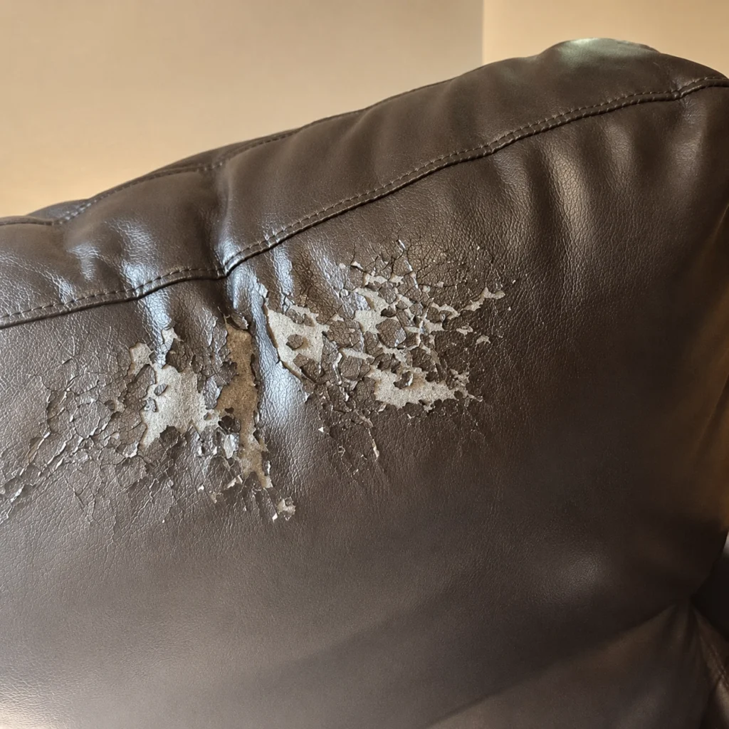 Close-up of peeling PU leather showing cracked coating and exposed underlying material