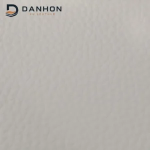 Close-up of light grey microfiber leather front surface with subtle irregular crinkle grain texture